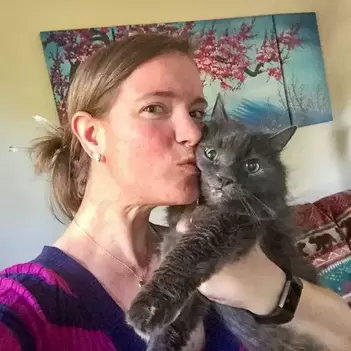 Brianna kissing her grey cat, Holee, on the cheek | Kitten KaZoedle