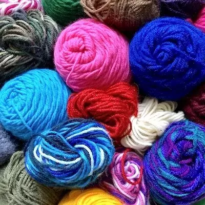 Overhead look of a dozen yarn skeins of various colors and designs | Kitten KaZoedle